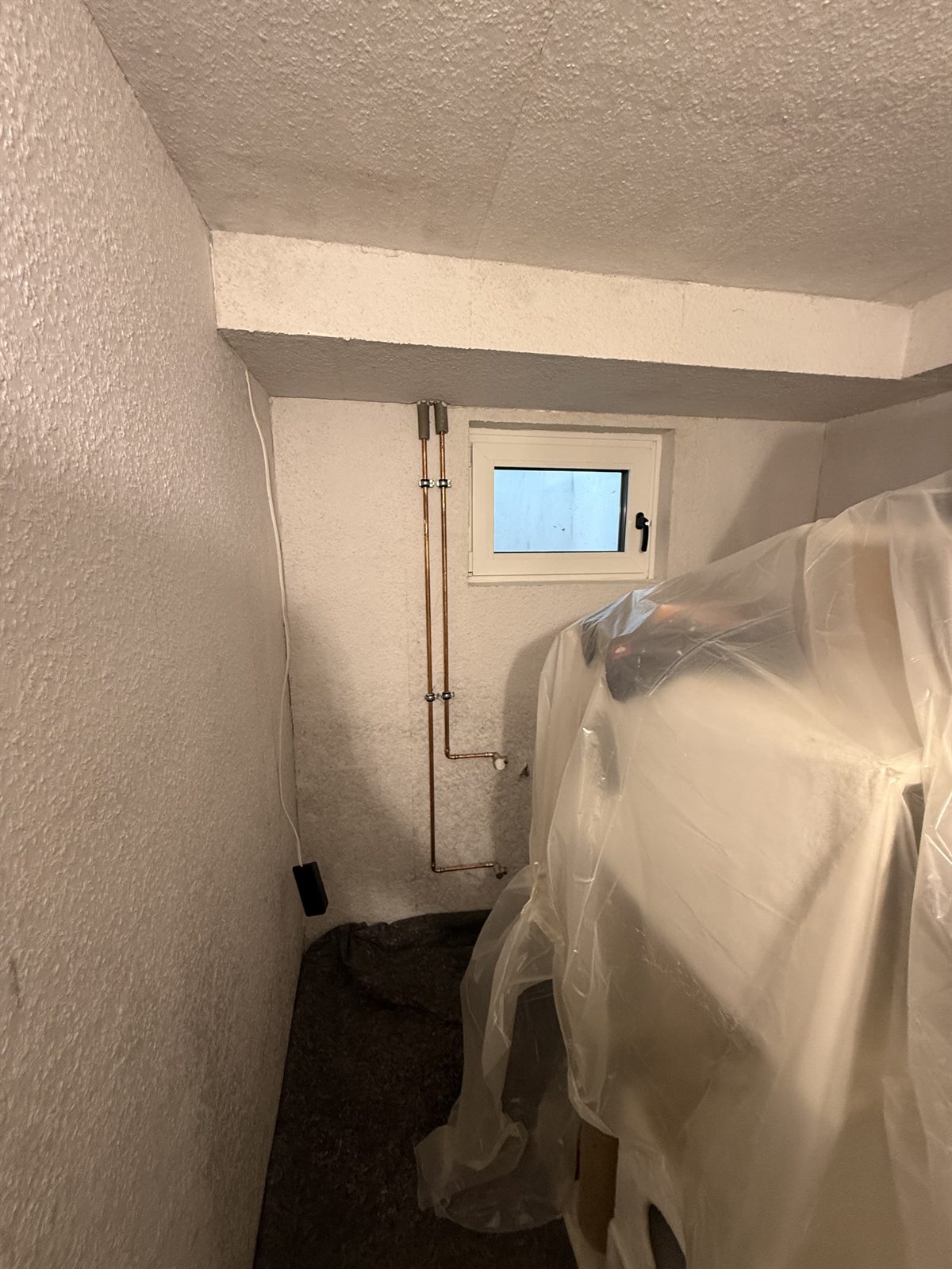 Tapeziertes Kellerzimmer mit sauber geschütztem Arbeitsbereich